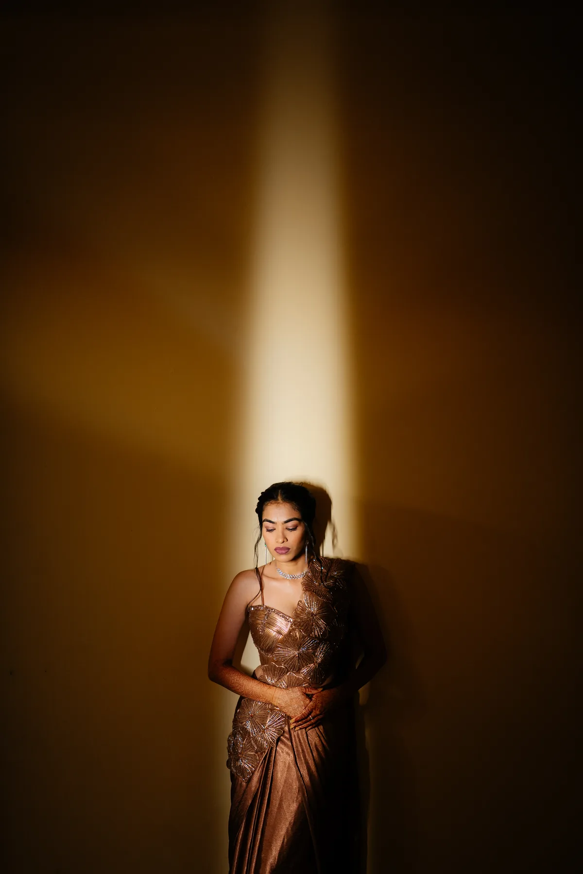 Portrait of a woman in a metallic dress in a pool of light
